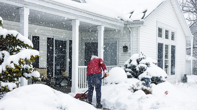 Person shoveling snow from their walkway during a big winter storm