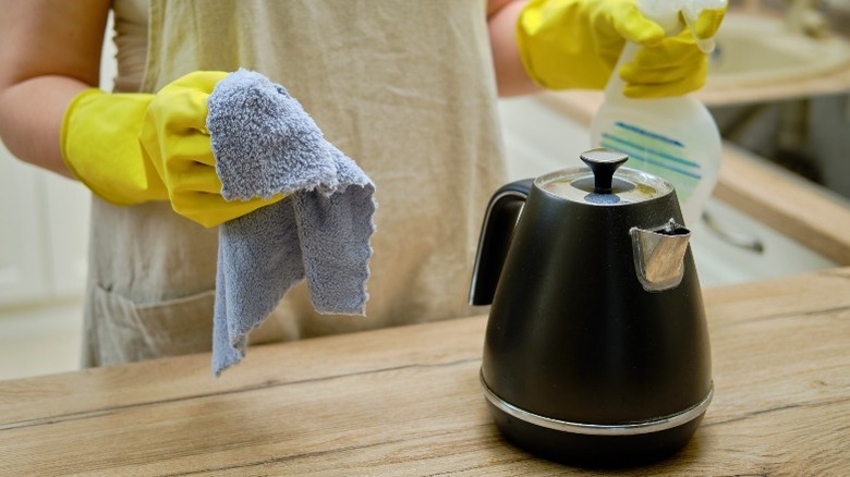 Woman cleaning a black kettle
