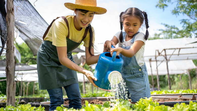 mother and daughter watering plants