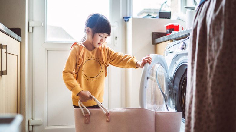 young girl doing laundry