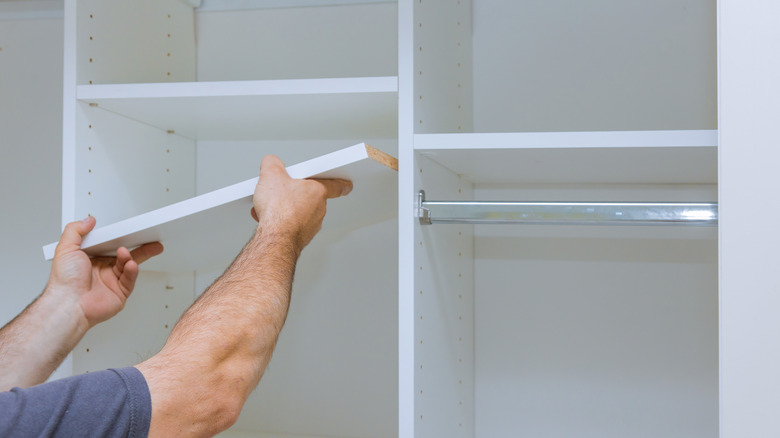 man installing closet shelf