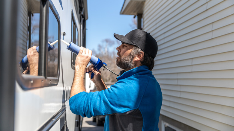 man caulking window