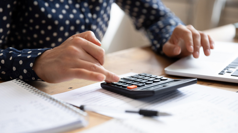 Woman using calculator and computer