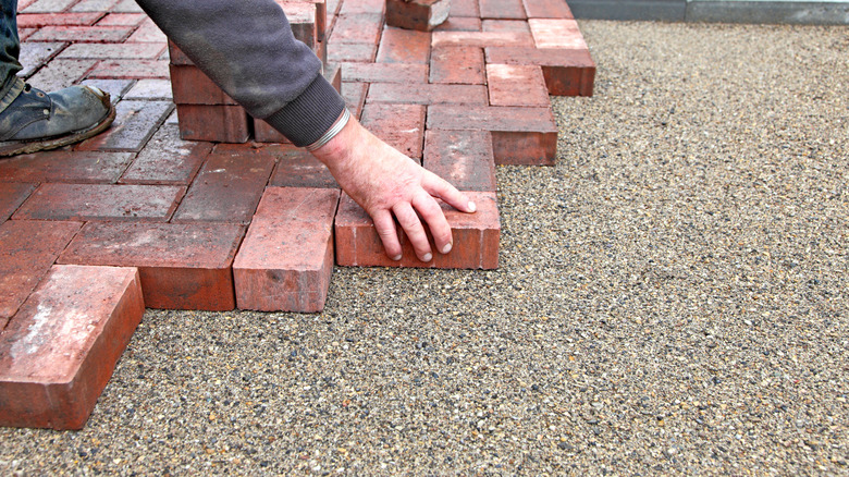 Person laying down paver stones