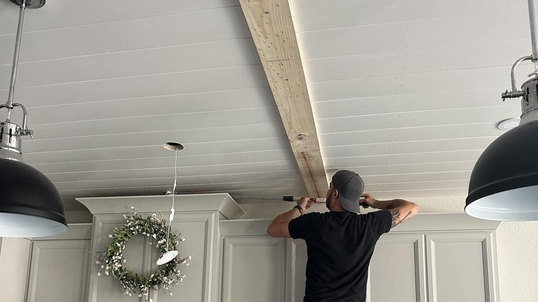 Person working on shiplap ceiling