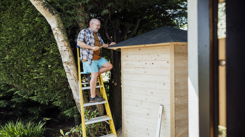 man repairing shed