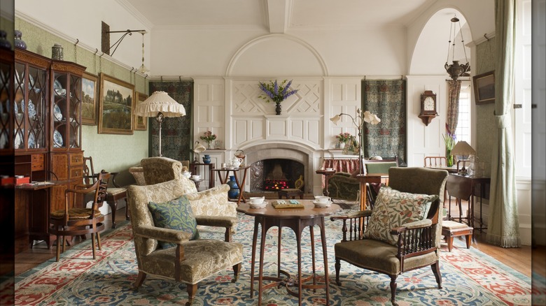 Period furniture, fabrics, and accessories are used in a light-filled sitting room