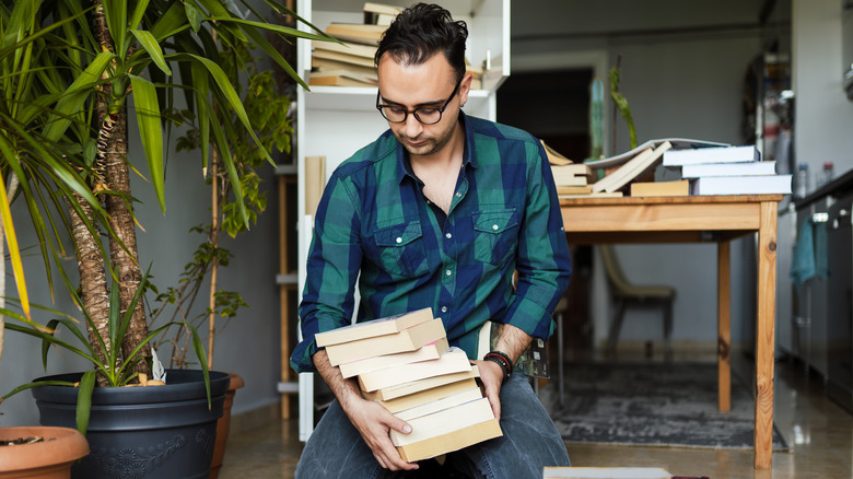 man decluttering books