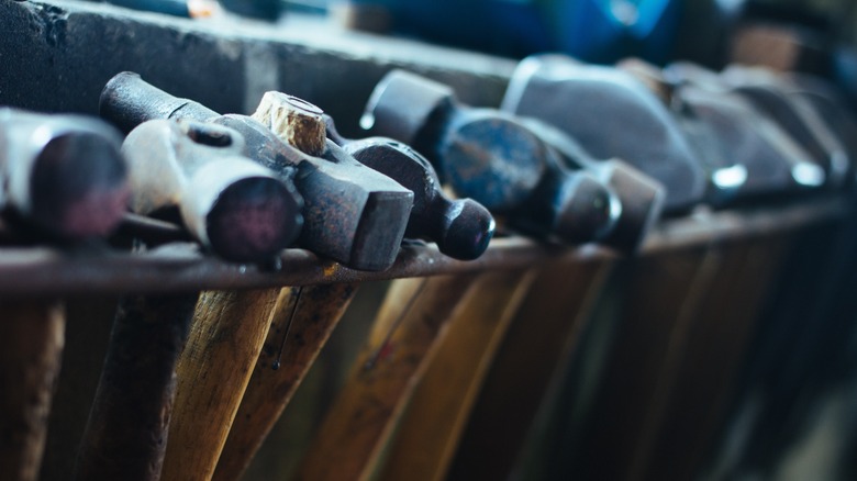 shelf of assorted metal and wood hammers