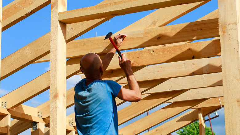 man using framing hammer for construction