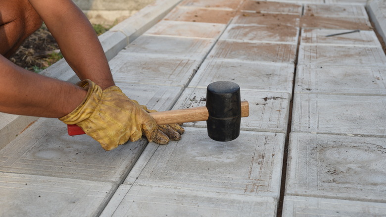 DIY-er using rubber mallet on tile