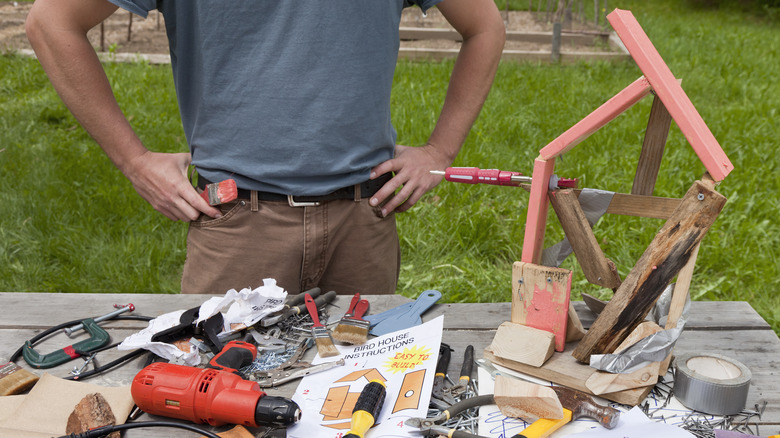 man building a birdhouse poorly