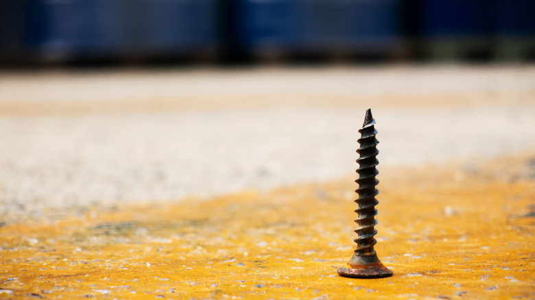 old and rusty screw on floor