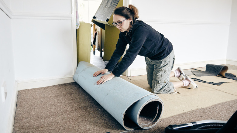 Woman rolling carpet up