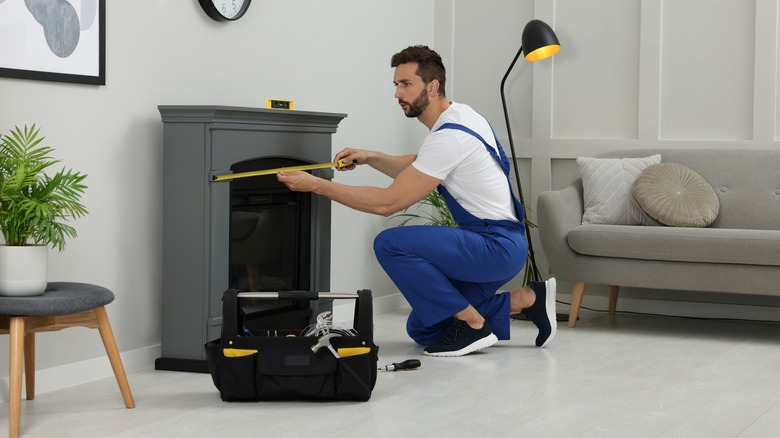 Person measuring fireplace