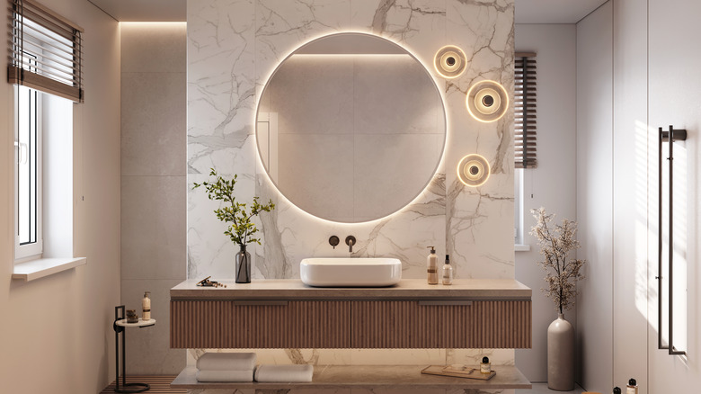 A modern bathroom is fitted with a backlit mirror