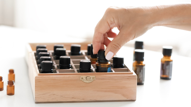 Woman taking essential oils from wooden box