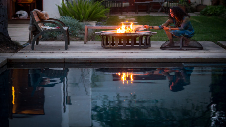 Patio area at night featuring an above-ground fire pit