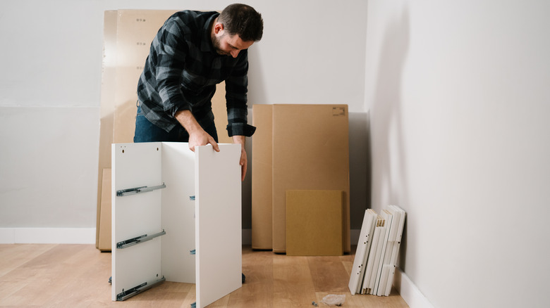 man builds IKEA shelf