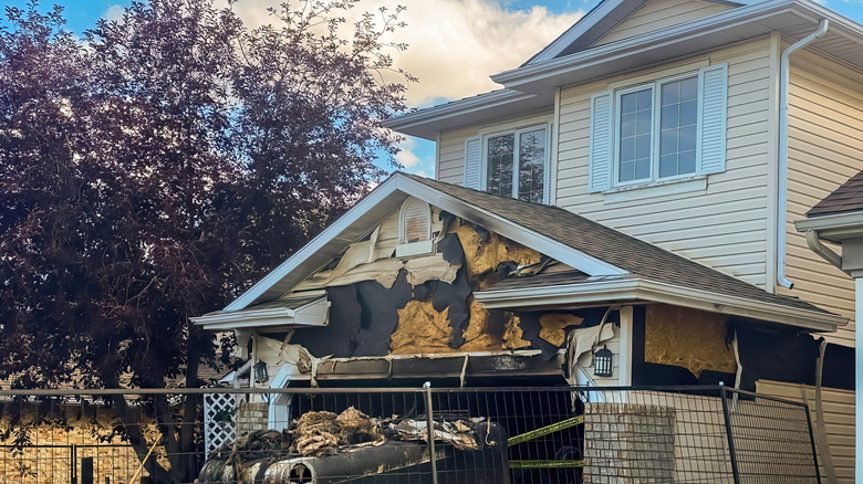 A yellow home's garage is fire damaged