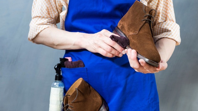 Man cleaning boots with cloth