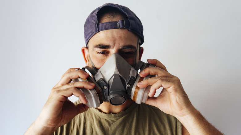 A man wears a lightweight half-mask respirator