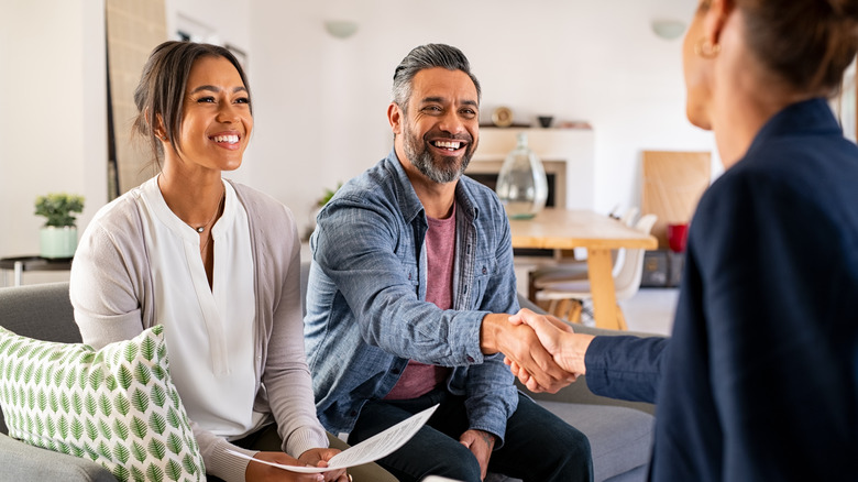 couple shaking hands with realtor