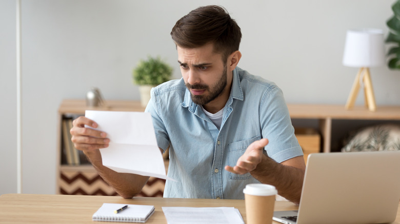 concerned man reads document 