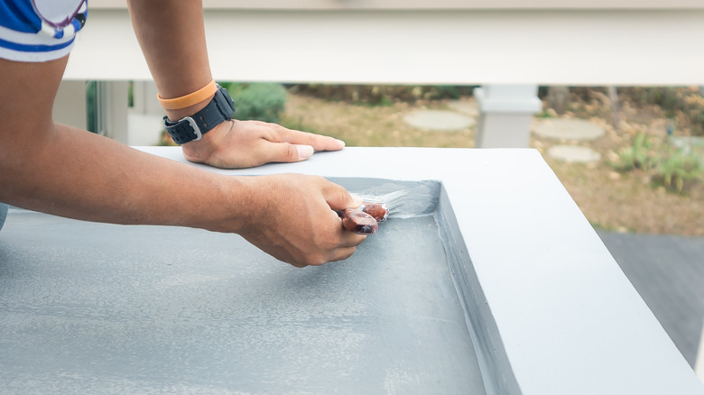 person painting outdoor deck