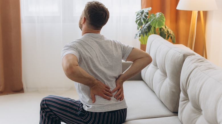 Man sitting on uncomfortable sofa