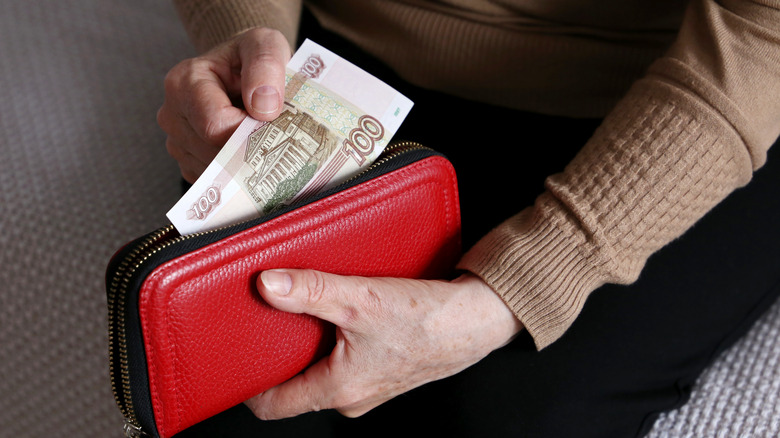 Person inserting money in purse