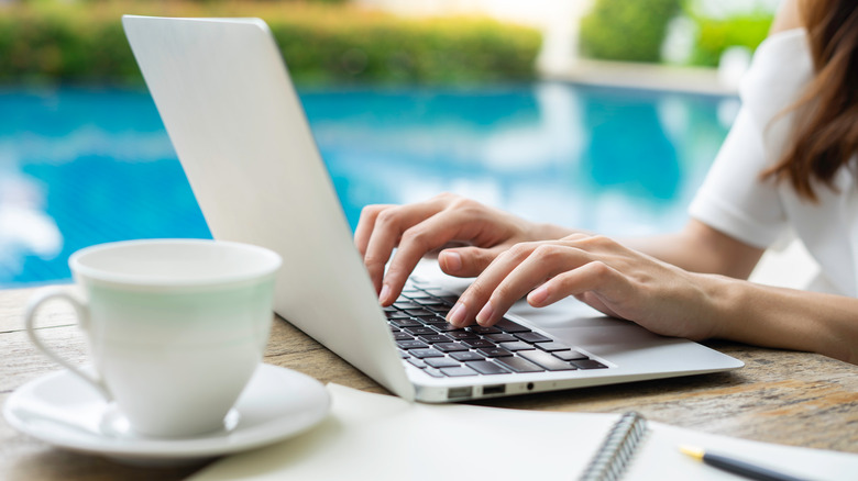 Person working on computer poolside