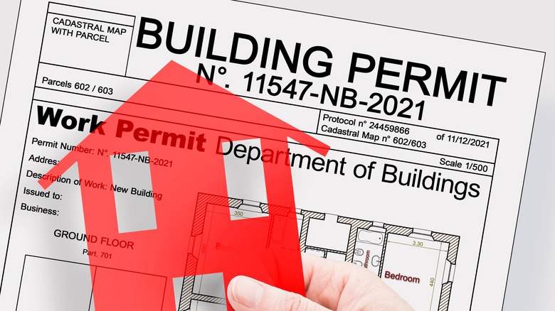building permit page behind red house