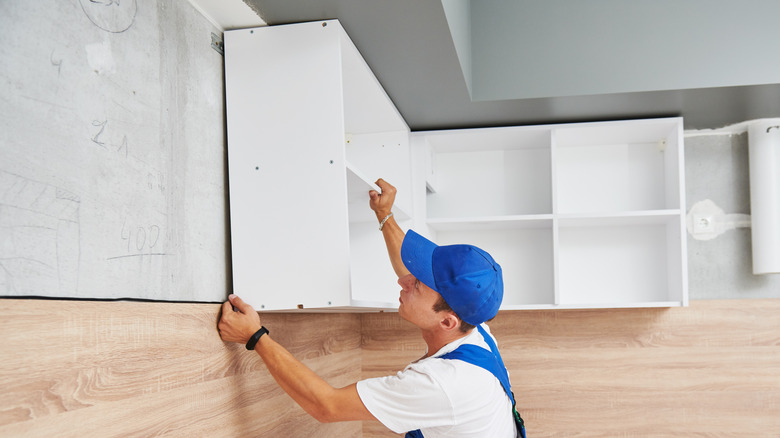 Person installing kitchen cabinet