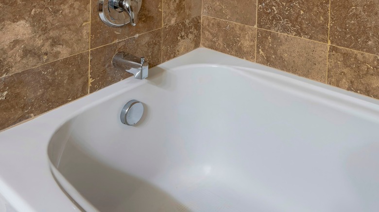 bathtub under brown tile