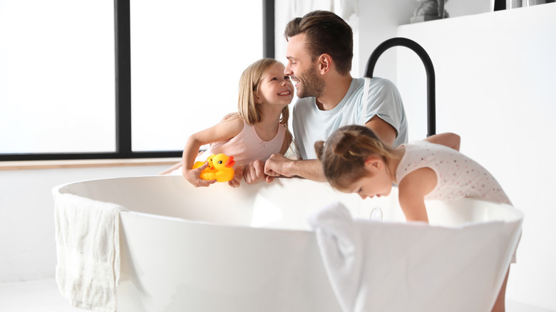 father and daughters by bathtub