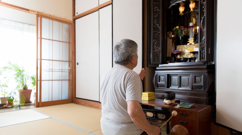 Person kneeling before home altar