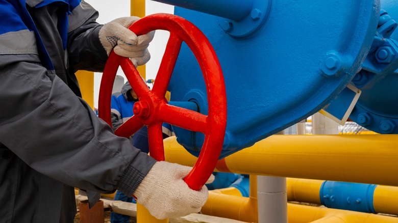 Worker opening valve at a gas pumping station