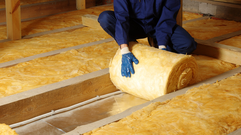 Construction worker insulating house attic