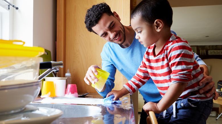 father and son washing dishes