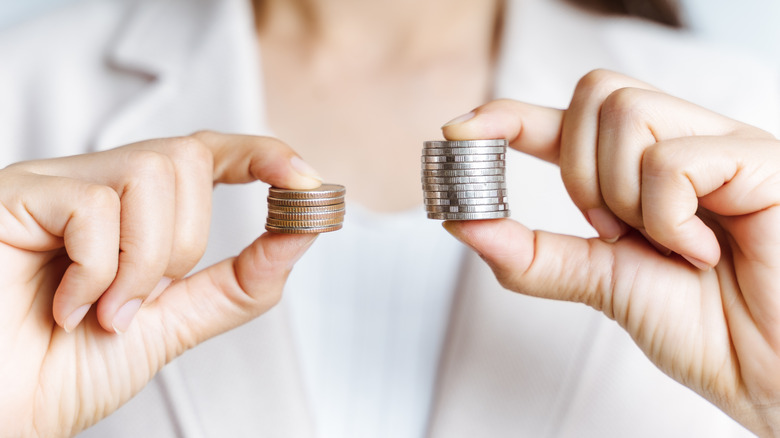 hands holding two stacks of coins