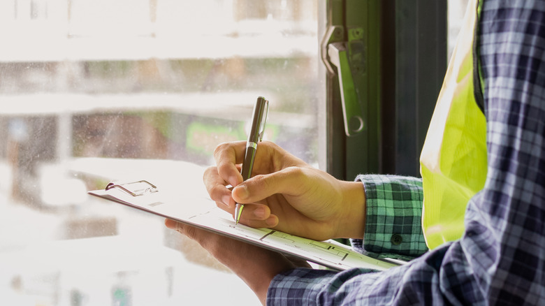 inspector writing on a clipboard