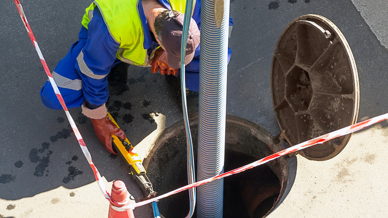 utility worker cleaning sewer pipes