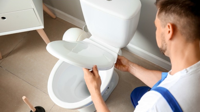 Man installing power flush toilet 