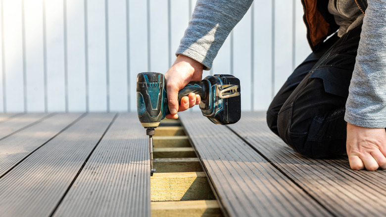 Person using impact driver on floor