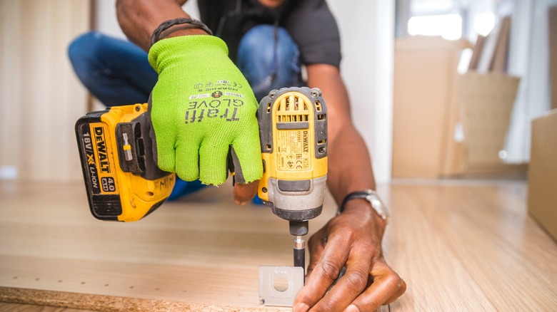 Man using driver on wood floor