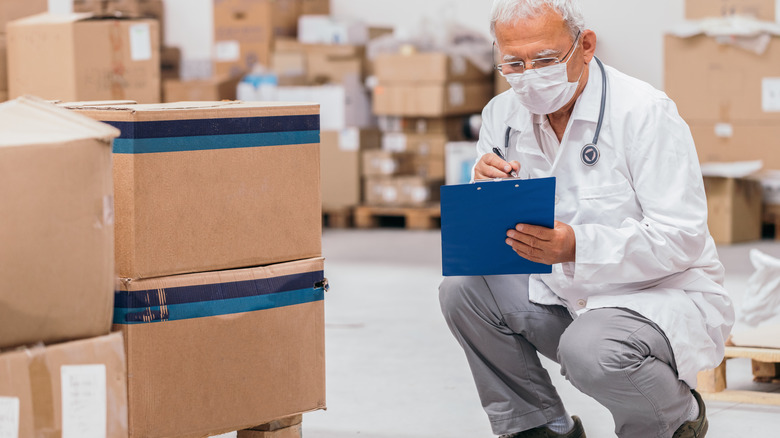 Doctor taking inventory of boxes