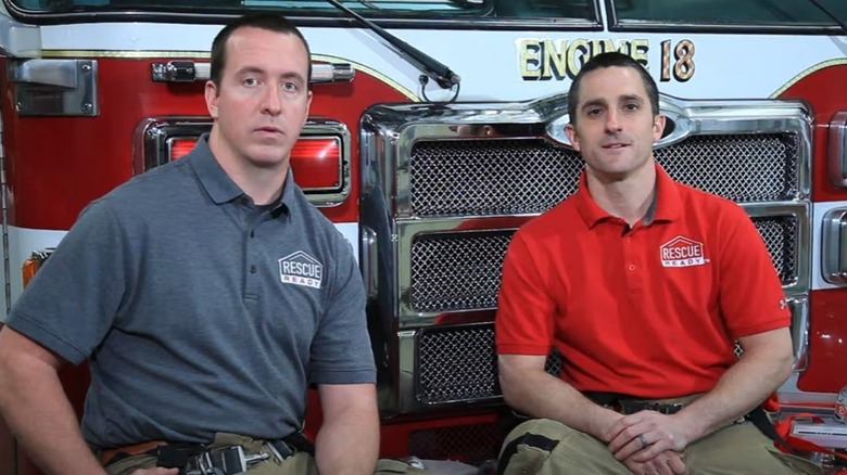 Eric Hartsfield and Brett Russell sitting on firetruck 