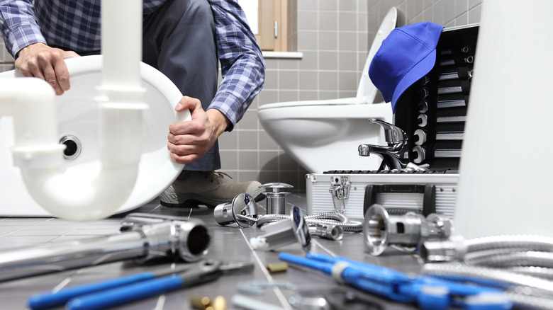 Plumber removing entire toilet