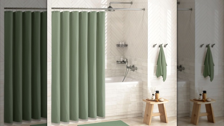 A green shower curtain hangs in a luxurious bathroom